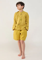 A Model Wearing Yellow Linen Kids Kei Timeless Linen Shorts- Ochre, curated by Only Ethikal