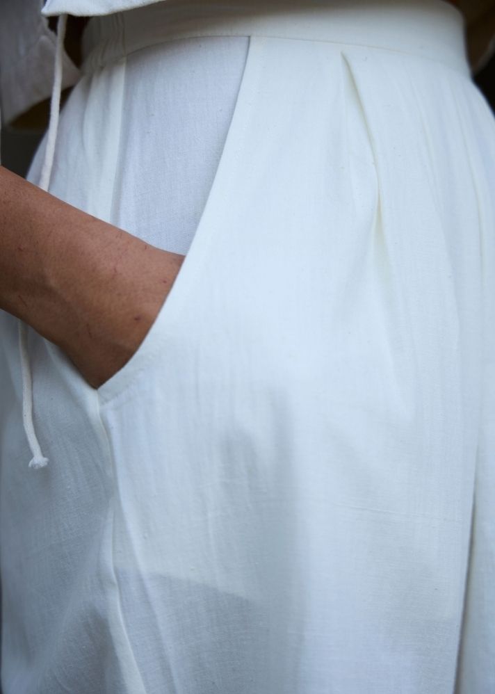 A Model Wearing White Cotton Khadi Woodstock Milk Pleated Pants, curated by Only Ethikal